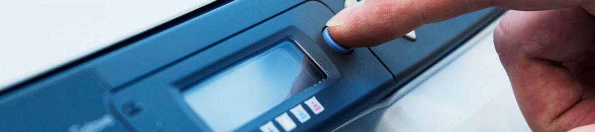 close-up of a hand pushing buttons on a multifunction printer